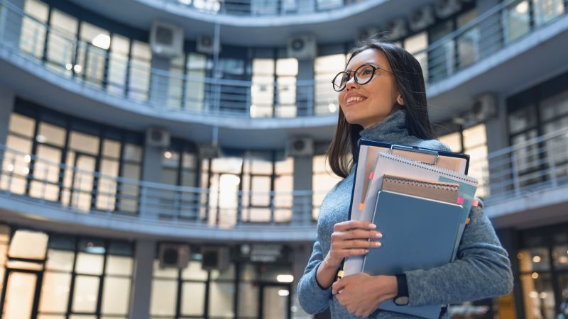 horizontal shot of smiling business woman standing