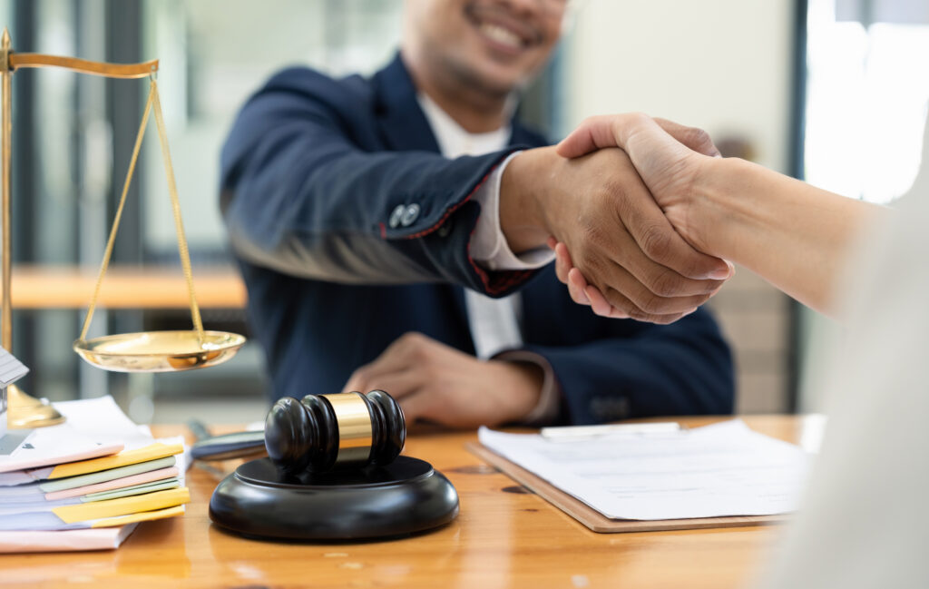 lawyer shaking hand with client after consultation discussing a contract agreement customer at courtroom, judge service concept.